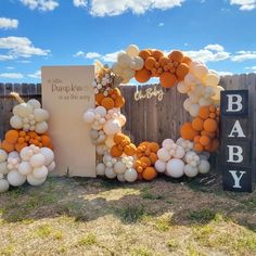 an outdoor baby shower with balloons on the side and a sign that says it's a boy