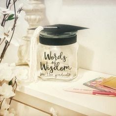 a graduation cap sits on top of a glass jar