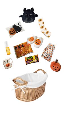 a basket filled with halloween items on top of a white table next to a stuffed animal