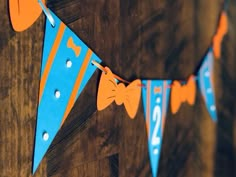 an orange and blue banner hanging on a wooden wall