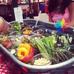 a woman standing in front of a table filled with food