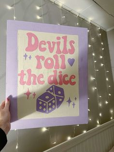 a person holding up a sign that says devil's roll the dice