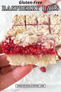 a hand holding up a raspberry bar with crumbs on top and the words gluten - free raspberry bars below it