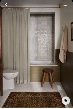 a white toilet sitting next to a bath tub in a bathroom under a shower curtain