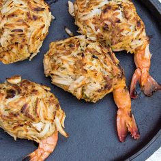 four cooked crab cakes on a black plate