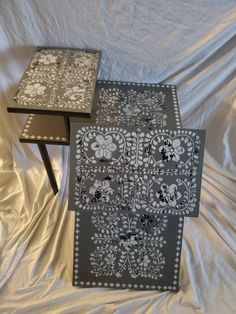 two side tables with black and white designs on them