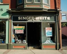 a store front with various signs on the windows and signage for different types of items