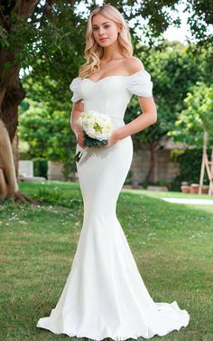 a woman in a white wedding dress posing for the camera with her hands on her hips