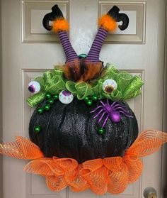 a door decorated for halloween with pumpkins and decorations