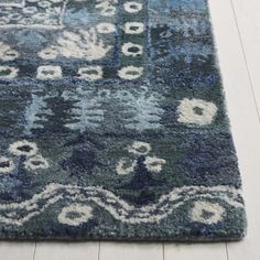 an area rug with blue and white colors on the floor in a living room or bedroom