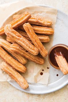 some churros and dipping sauce on a plate