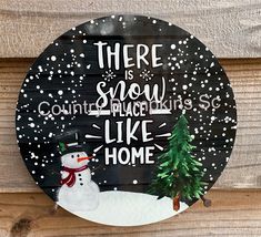 there is snow place like home sign on the side of a wooden fence with a snowman