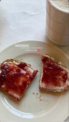 two pieces of toast with jam on them sitting on a plate next to a cup