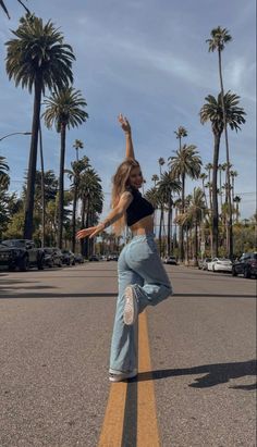 a woman is doing a skateboard trick in the street