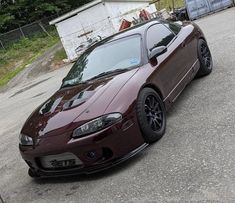 a maroon sports car parked on the street