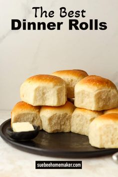 the best dinner rolls on a black plate with butter and spoons next to it