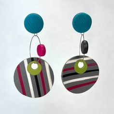 two circular earrings with colorful circles hanging from the end of each earring, on a white background