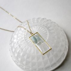 ̩̩͙✩ Handmade gold colored necklace with a blue aquamarine crystal pendant ✩*̩̩͙*˚ Overview: ⋆ 1.75 x 0.75 inch aquamarine pendant in yellow gold colored rectangular frame ⋆ 20 inch gold stainless steel chain with lobster clasp closure ⋆ Handmade and original design ⋆ March birthstone ⋆ Throat chakra stone This pendant is made of tiny tumbled aquamarine stones sealed in a durable, clear resin window. The crystals partially extend beyond the surface of the resin and the back surface of the pendant is flat for ease of wear. The 20 inch/51 cm yellow gold colored chain is made of stainless steel and falls past the collarbone, although this will vary by person. The chain's width is 2 mm. Aquamarine is a blue variety of beryl - same as emerald! - whose name is derived from the latin word for sea Gold Aquamarine Birthstone Necklace, Minimalist Gold Aquamarine Jewelry, Gold Aquamarine Pendant Necklace, Rectangular Light Blue Jewelry Gift, Colored Necklace, March Birthstone Jewelry, Aquamarine Pendant, Aquamarine Necklace, Aquamarine Crystal