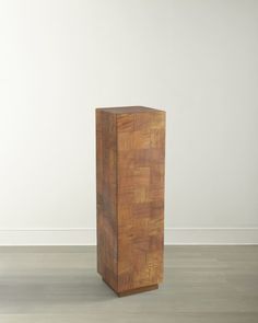 a wooden box sitting on top of a hard wood floor next to a white wall