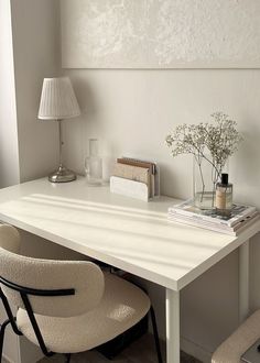 a white desk with two chairs and a lamp