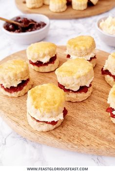 biscuits and jams are arranged on a wooden platter