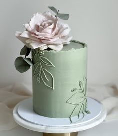 there is a green cake with flowers on it