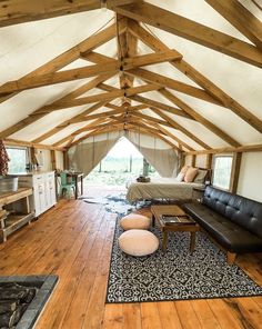 a living room filled with furniture and a large wooden floor covered in wood planks