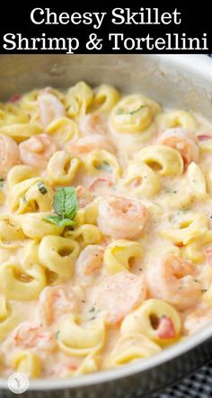 a pot filled with pasta and shrimp on top of a stove