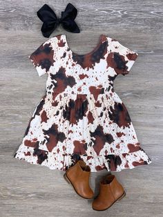 Moo-ve over to adorable style with our Brown Cow Brown Cow Girls Short Sleeve Dress! This charming dress features a delightful brown and white cow print that's sure to delight any little animal lover. With its comfortable short sleeves and playful design, this dress is perfect for both casual outings and imaginative play. Let her channel her inner farm girl fashionista! And be sure to check out our other must have new arrivals. INCLUDES: Dress FIT: This item is true to size FABRIC & CARE: Cotton Cute Brown Spring Dress, Cute Brown Summer Dress, Cute Brown Cotton Dress, Brown Summer Dresses With Flutter Sleeves, Cute Fitted Brown Dress, Brown Short Sleeve Summer Dress, Brown And White Cow, Ohio Girls, White Cow Print