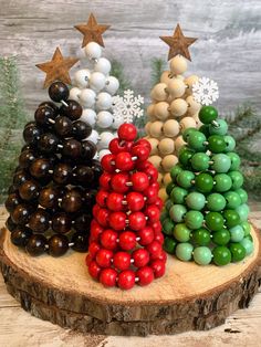 three christmas trees made out of beads on a tree stump with stars in the background