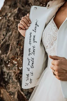 a woman in a wedding dress holding up a white purse with writing on it and the words, i love you to the moon and back