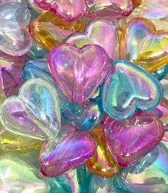 there are many heart shaped glass beads in the bowl