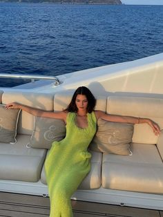 a woman in a green dress sitting on a boat