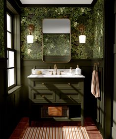 a bathroom with green wallpaper and two sinks