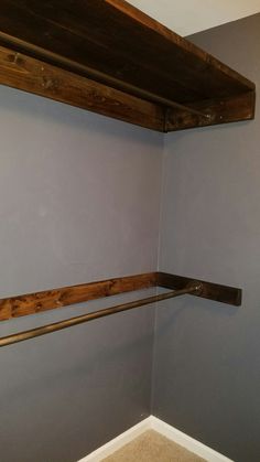 the corner of a room with two wooden shelves on one wall and a toilet in the other