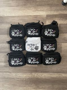 black and white bags with let's do the world written on them sitting on top of a wooden floor