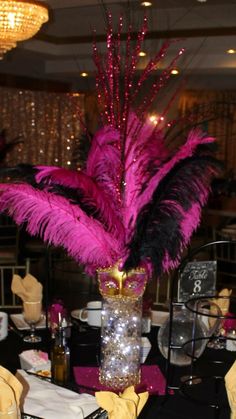 the centerpiece is decorated with feathers and sequins