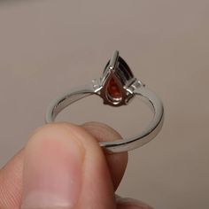 This is a gorgeous handmade creation. Its beauty is its simplicity & Elegance. The 6*9 mm pear shape faceted natural garnet is crafted in solid sterling silver and with rhodium plated. All item is sent in a beautiful gift box If you have any idea of design your ring,pls contact me directly. You can realize more lovely stuff clicking the link https://www.etsy.com/shop/knightjewelry?refshopsection_shophome_leftnav Please leave the correct address and you phone number for delivering successfull Pear-shaped Ruby Rings, Teardrop Gemstone Ring For Proposal, Classic Teardrop Ruby Ring, Teardrop Ruby Ring For Anniversary, Pear-shaped Ruby Promise Ring In Fine Jewelry Style, Pear-shaped Birthstone Promise Ring, Pear-shaped Ruby Ring With Halo Setting, Formal Teardrop Ruby Ring, Pear-shaped Topaz Promise Ring