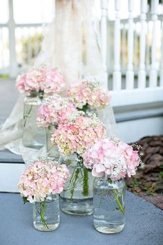 pink flowers in mason jars on a blue table