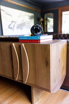 a wooden cabinet with books on top of it