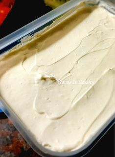 a container filled with white frosting sitting on top of a counter