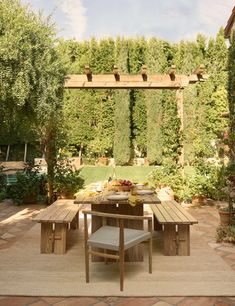 an outdoor dining area with wooden furniture and greenery