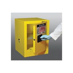 a person in white shirt and gloves opening a yellow safe box with the door open