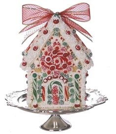 a gingerbread house decorated with candy canes and candies on a silver platter