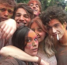 a group of young people posing for a photo with their faces painted in different colors