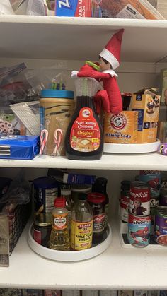 an elf is sitting on top of a shelf in a store filled with canned food