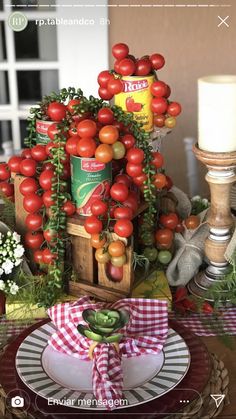 a table with tomatoes and other vegetables on it, along with an arrangement of candles