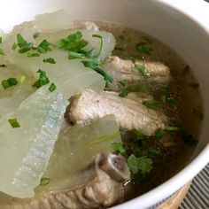 a white bowl filled with meat and vegetables