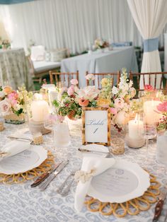 the table is set with place settings and candles