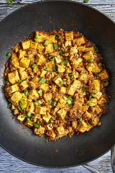 a pan filled with tofu and green onions